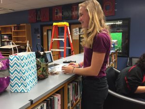 Linnea standing in the library, working on homework during Mustang Block. (Photo by Caroline Perez)