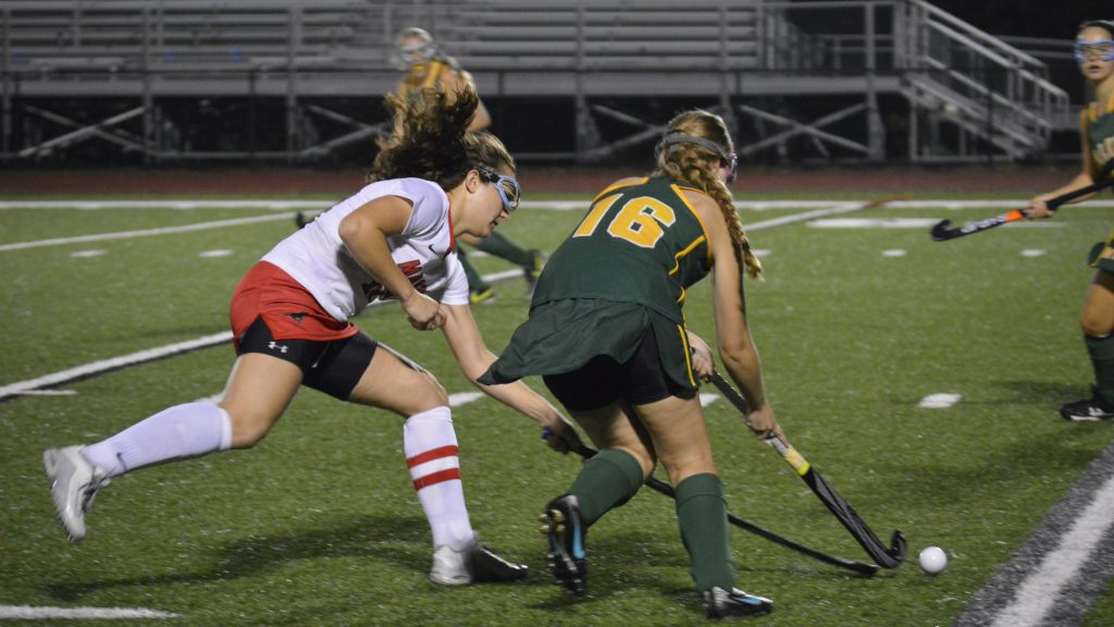 The field hockey players talk with Coach Crider at halftime during the Conference Finals vs. Maggie Walker. The match up ended in a 0-2 loss for the Mustangs, however as conference runner-ups, they were able to advance to the Region Tournament. (Photo by Grace Hughes)