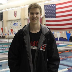 Senior Justin Britton poses for a photo at a Mason swim meet. Britton is a dedicated swimmer and an important leader on the Mason team.