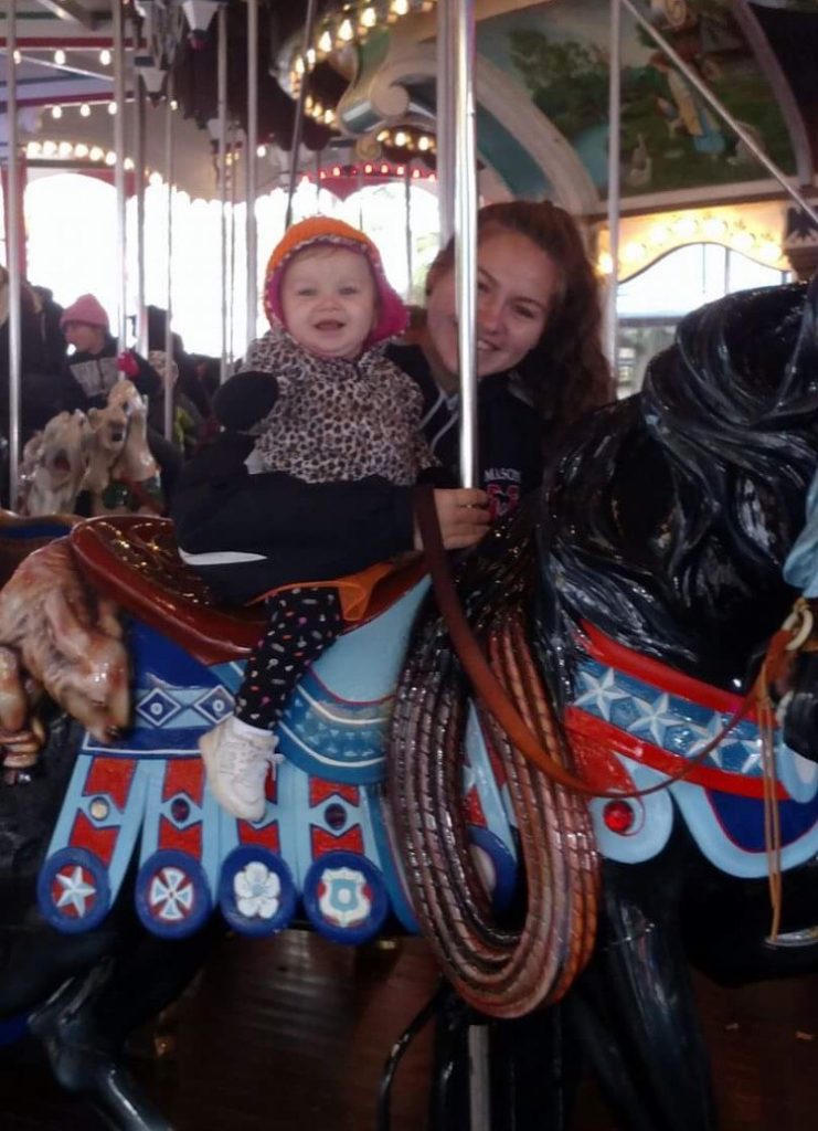 McKayla Bobitski and her baby sister on a merry-go-round.