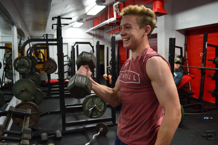 A student lifts weights in the weight room