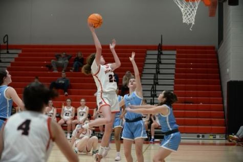 Stufft leaps up and scores a basket for her team over two defenders. (Photo courtesy of Nora Stufft)