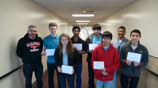 Students holding up National Merit scholarship award