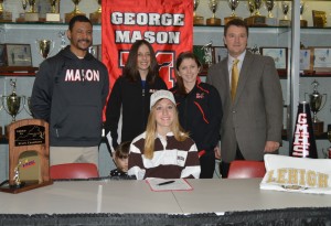 Student poses with principal, coach, and superintendent after signing letter of intent