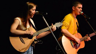Two students playing guitar and singing