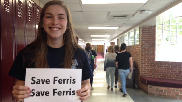 Student in the hallway with a Save Ferris sign