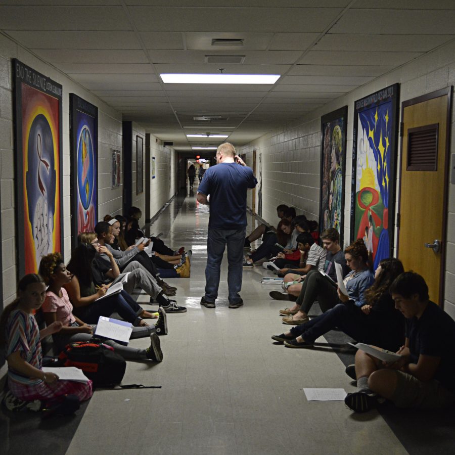 Students sit in the hallway doing work