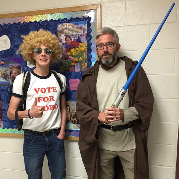 A student and a teacher pose together in costumes