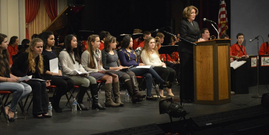 English teacher and moderator, Mrs. Bridget Dean- Pratt welcomes the contestants and guests.  The annual Poetry Out Loud competition was held on December 4, which featured eight GMHS students. Contestants seated left to right: Shannon Rodgers, Grace Keenan, Jaden White, Andrea Dilao, Manon Diz, Annie Parnell, Tina Dao, and Mary Catherine Donovan. (Photo by Jessie Beddow) 