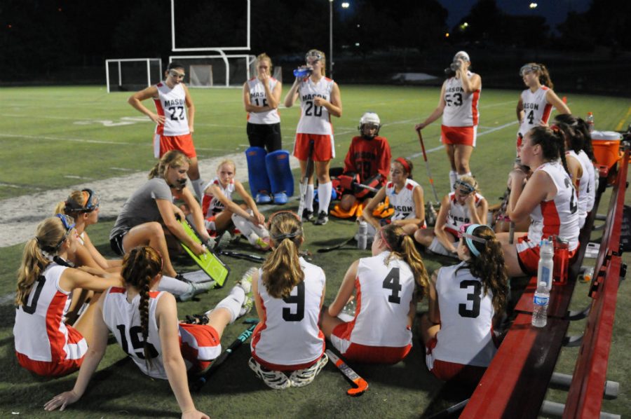 The varsity field hockey team gathers around Coach Crider at halftime to discuss strategy. (Photo credit: LifeTouch Photography) 