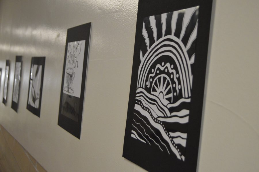 A variety of pieces of Contrato artwork pasted on the ramp hallway near the auditorium. These projects were assigned for art classes 1-4.