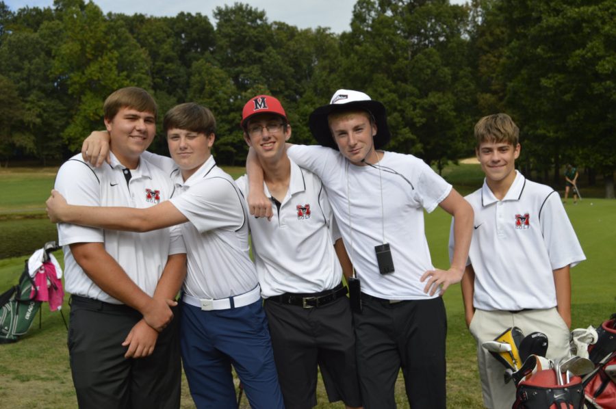 Golf team members (from left to right) senior Daniel Schlitt, sophomore George Gilligan,  senior Noah Anderson, senior Devin Thomas, and freshman Nicholas Wells pose for a photo at the Penderbrook match. Mason’s golf teammates are all very close-knit among athletes of all ages. (Photo by Matthew Ng).