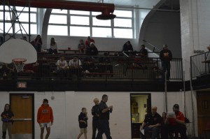 Mason wrestlers sit up on the bleachers waiting for their matches.