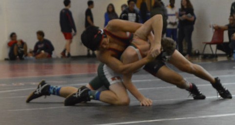 A wrestler holding his opponent by the head.