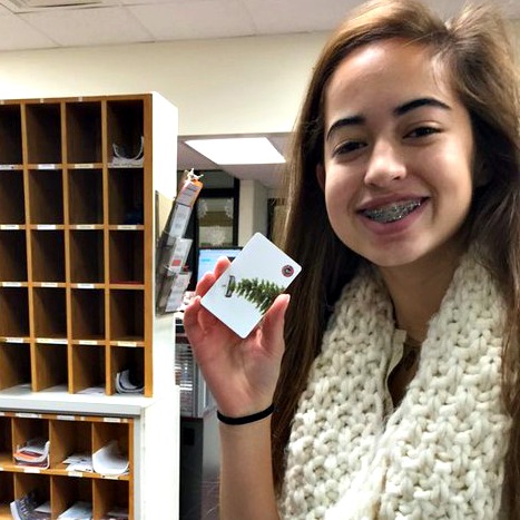 A student holding a Chipotle gift card prize she received for being a December Project MBC monthly winner.