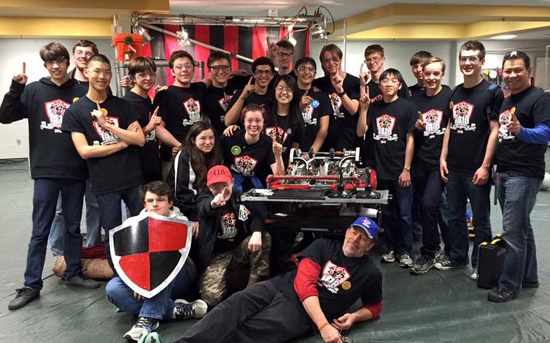 The robotics team posing with their trophy.