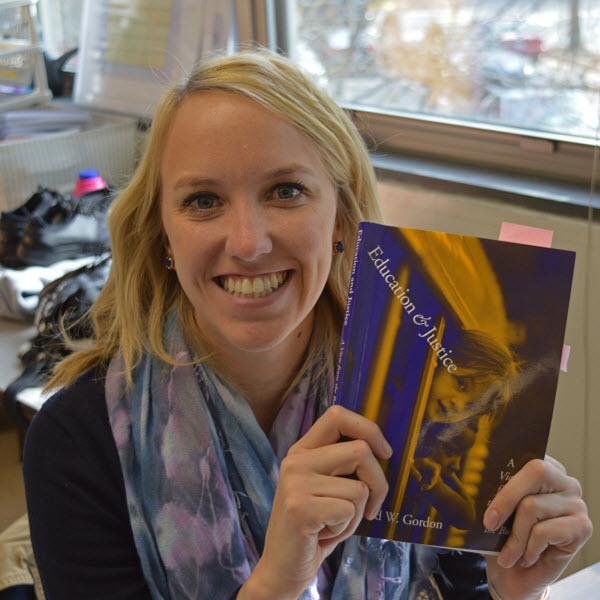 Alexandra Ware poses with the book she is reading for her degree in Social Foundations. She will complete her degree in July. (Photo by Eric Clinton)