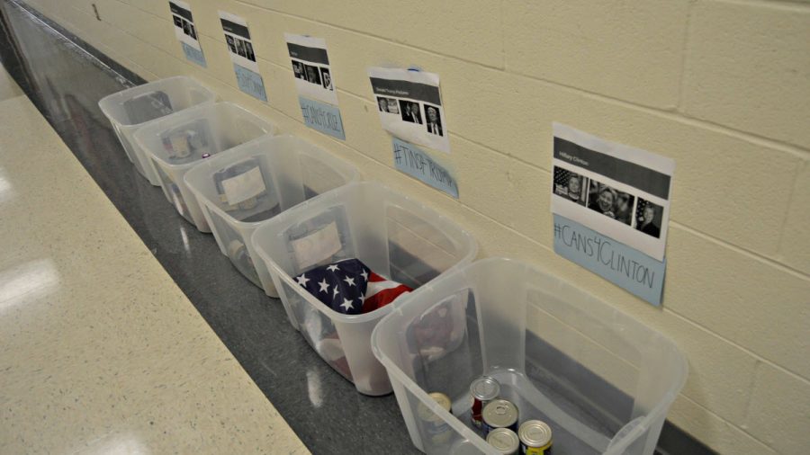 This photo depicts the tubs in the hallway outside of the cafeteria to collect cans for people in need. Students place canned foods in the tub that represents the candidate that they endorse. (Photo by Sierra Sulc)