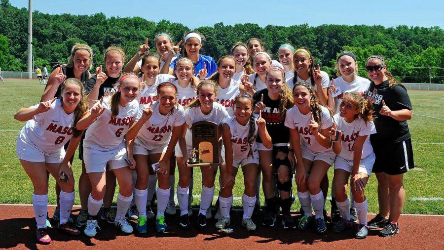 The varsity girls soccer team poses with the state trophy after clinching their ninth consecutive state title, the first team in Virginia 2A history to do so. (Photo Courtesy of Brad Mills)