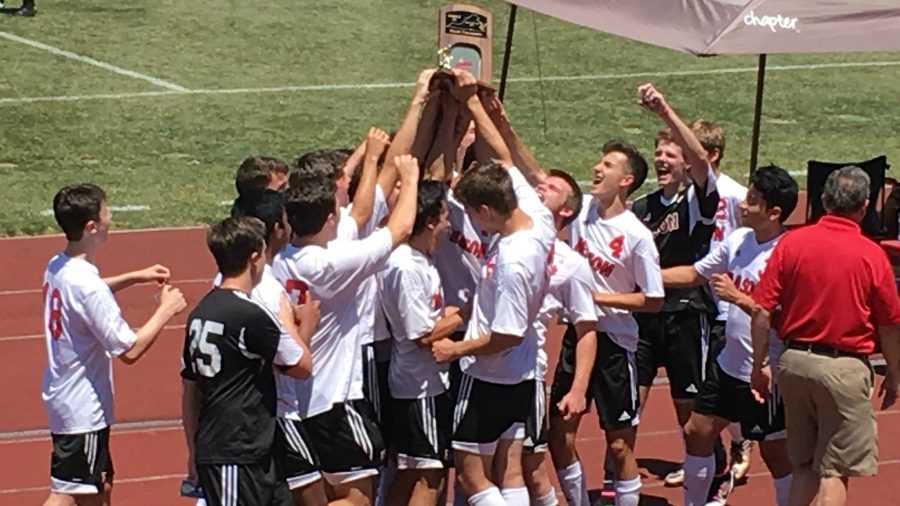 The boys soccer team celebrate their state championship victory. This is their fourth consecutive state title and seventh win since losing their 59 game winning streak in May. (Photo courtesy of Dana Sembara)