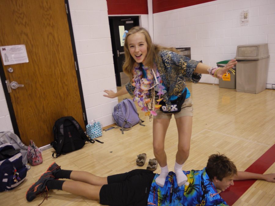 A+girl+dressed+as+a+tacky+tourist+standing+on+a+classmate+acting+as+a+surfboard.