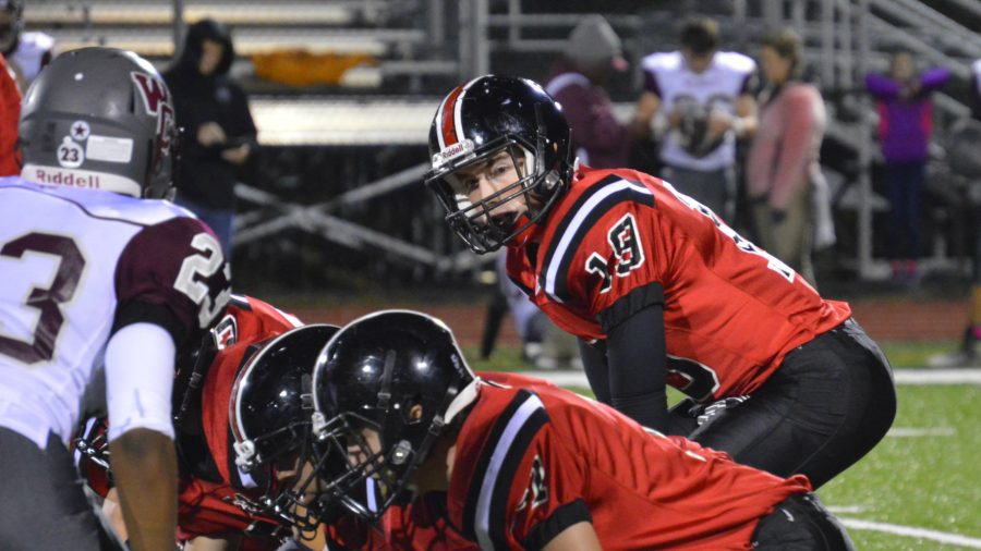 Junior quarterback Thomas Creed takes a snap behind his Offensive Line (Photo Credit: Kate Karstens)