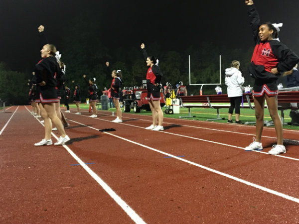 Cheerleaders performing a routine on the track.
