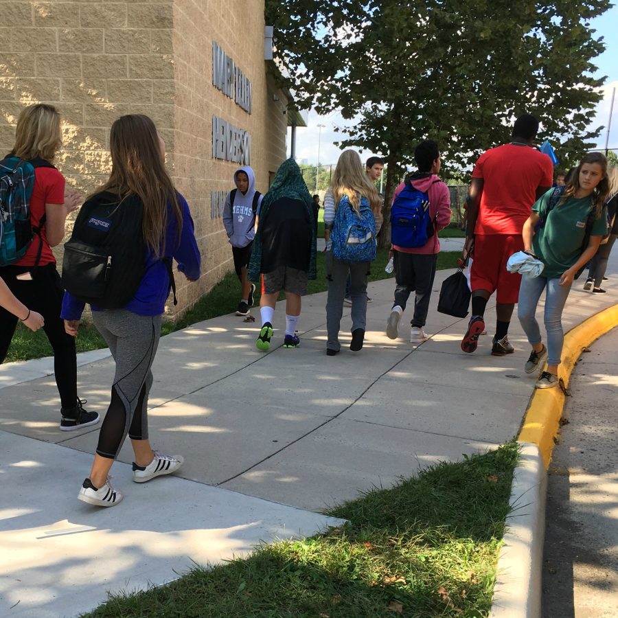 Students gathering at the bus loop after school.