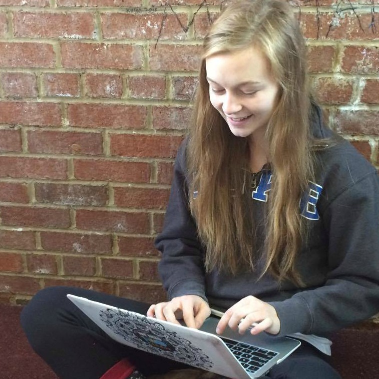 Senior Samantha Steger writing on a laptop