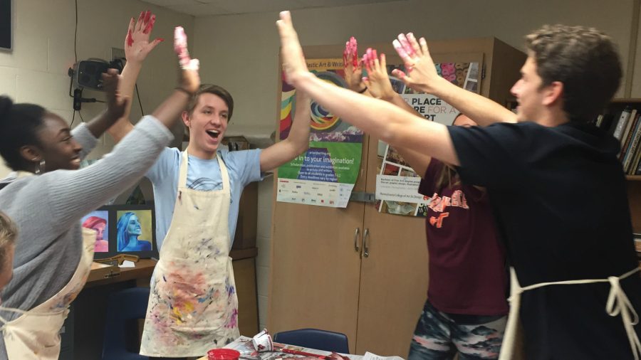 Students high five after making a doormat.