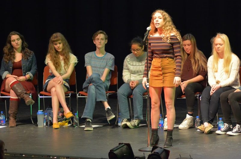 Senior Meghan Murphy recites her poem as the other 7 contestants watch from their seats. The other competitors were (pictured from left to right) Megan Hayes, Grace Keenan, Miles Jackson, AnaKarin Iturralde, Rebecca Horovitz and Elisabeth Snyder. Photo Courtesy of FCCPS Morning Announcements.
