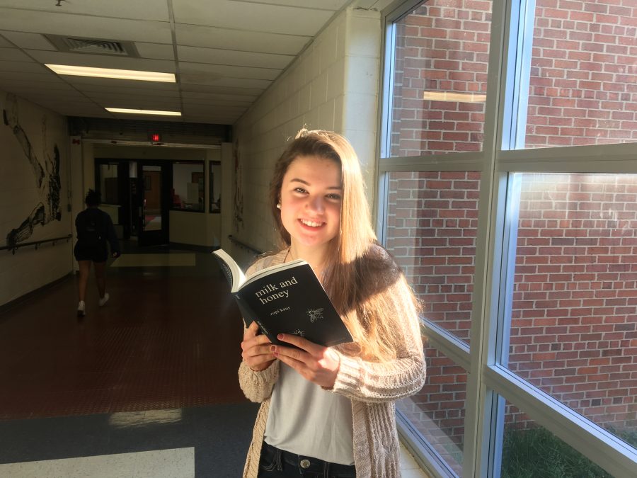 Freshman Grace Tarpgard holding a copy of Rupi Kaurs milk and honey. This poetry book has grown tremendously popular, selling millions of copies and spending 77 weeks at the top of the New York Times Paperback Fiction Bestseller List. Kaur is one of many rising Instagram poets who are known to write with minimalism. (Photo by Sequoia Wyckoff)