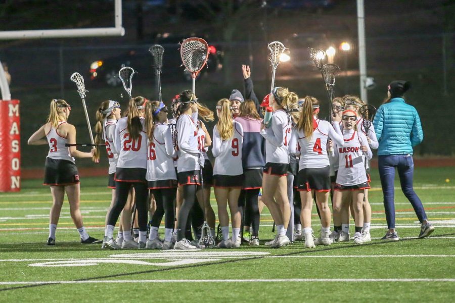 The lacrosse team huddling during a game. The girls lacrosse team has gone 7-0 so far, despite losing six seniors last year. They look to place at States again and beating their rivals, Riverside. (Photo courtesy of LifeTouch)