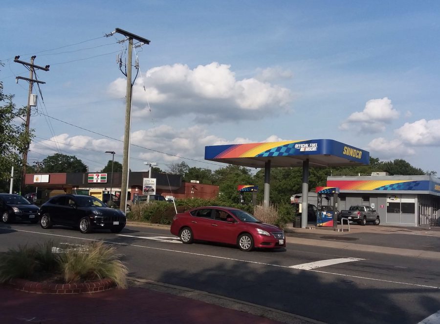 A car drives in front of a gas station.
