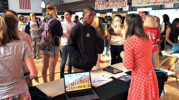 Student talks with presenter at the recent Wild Horse Wednesday Service Fair, while other students linger in the background.