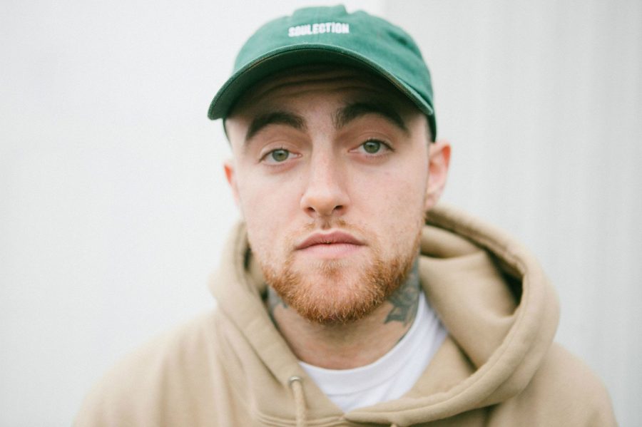 Rapper, Mac Miller, stares at the camera with a blank face.