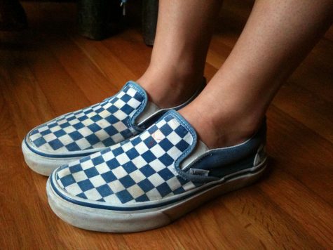 Close up of light blue and white checkered vans on someone’s feet.