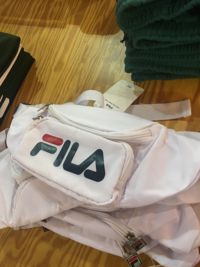 A white Fila fanny pack on a shelf in a store.