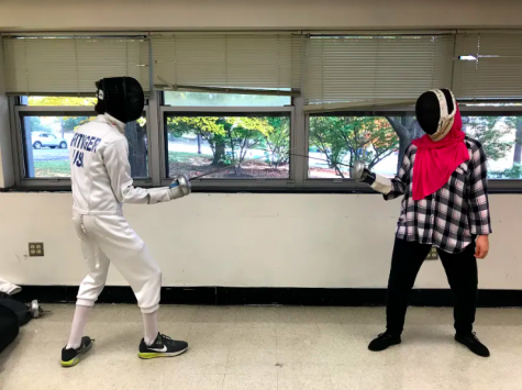 Senior Zainab Youssri and sophomore Luke Reitinger practice during a fencing club meeting.