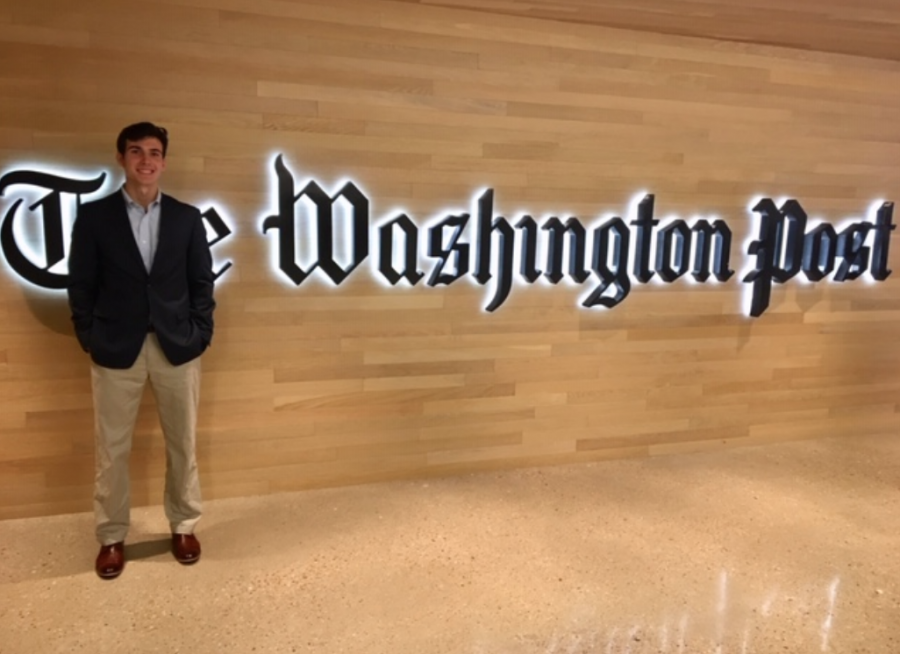 A boy stands next to a Washington Post Logo