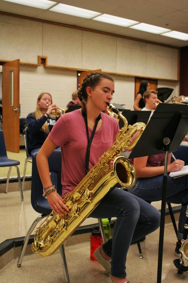 Girl plays bari saxophone.
