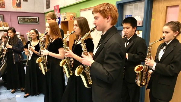 Students play instruments in all black.