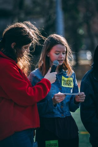 Girl holds microphone while another girl speaks.