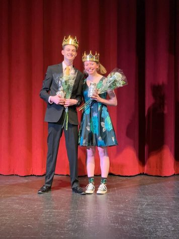 Miles Jackson and Sigrid Edson stand next to each other holding flowers in their formal attire following the show.