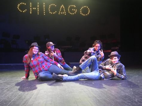 Four students pose on stage.