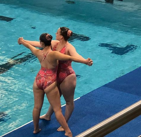 Two girls perform deckwork before diving into the pool.