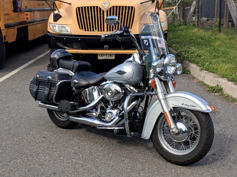 A Harley Davidson motorcycle sits parked outside. 