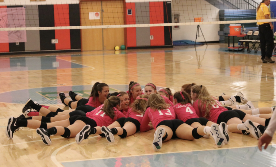 Last year’s varsity volleyball team celebrates Dig Pink before the start of their game. This year, the Dig Pink game will take place on October 8. 
