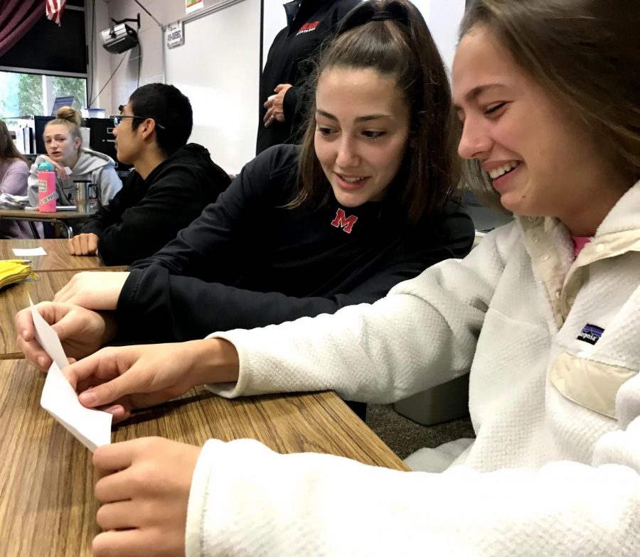 Two students look at a notecard