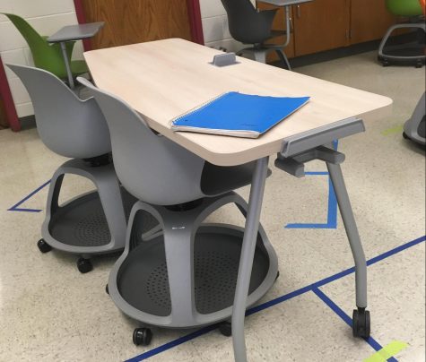 A desk with two rolling chairs